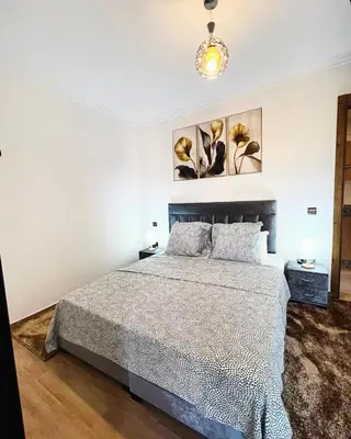 a bedroom with a bed and two paintings on the wall at Cozy apartment in city center in Marrakech