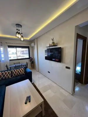 a living room with a couch and a tv on a wall at Cozy apartment in city center in Marrakech