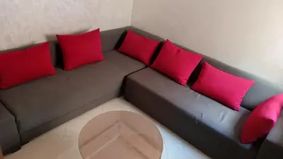 a couch with red and pink pillows in a room at Marrakech Chic and moderne appartement in Marrakech