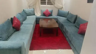 a living room with a blue couch with red pillows at Marrakech Chic and moderne appartement in Marrakech