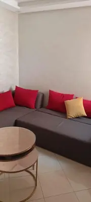 a couch with red and yellow pillows and a table at Marrakech Chic and moderne appartement in Marrakech