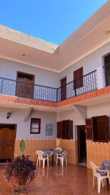a courtyard with tables and chairs in a building at Auberge de Jeunesse Marrakech-Asni in Marrakech