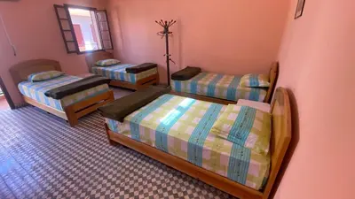 a room with three beds and a mirror at Auberge de Jeunesse Marrakech-Asni in Marrakech