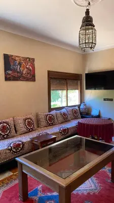 a living room with a couch and a glass table at Auberge de Jeunesse Marrakech-Asni in Marrakech