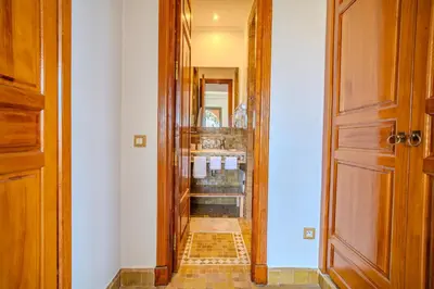 a bathroom with a walk in shower and a door at Family Stay aux jardins de la palmeraie in Marrakech