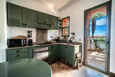 a kitchen with green cabinets and a table at Family Stay aux jardins de la palmeraie in Marrakech