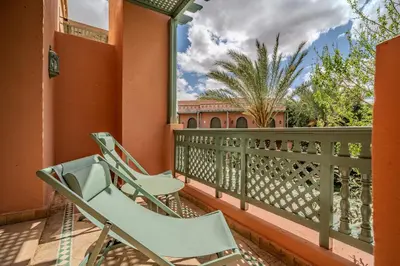a pair of chairs on a balcony of a house at Family Stay aux jardins de la palmeraie in Marrakech