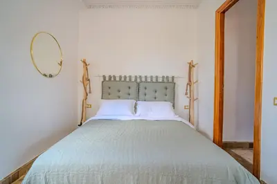 a bedroom with a large bed with a mirror at Family Stay aux jardins de la palmeraie in Marrakech