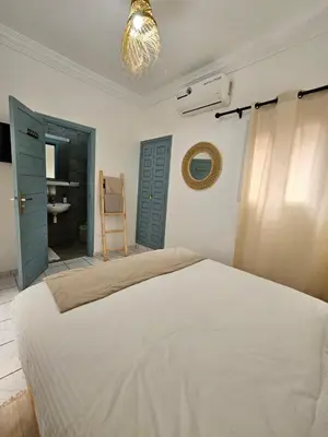a bedroom with a white bed and a bathroom at Riad karya MEDINA in Marrakech