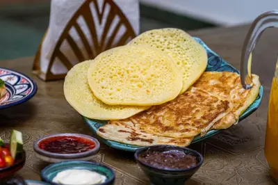 a plate of food with pancakes on a table at Riad Dekkak, Maison complète en exclusivité in Marrakech