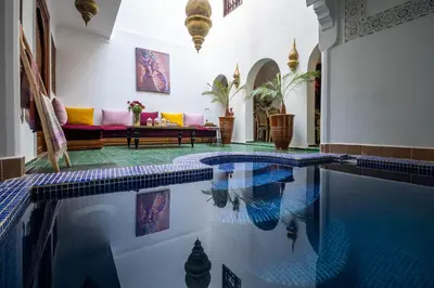 a swimming pool in a house with a living room at Riad Dekkak, Maison complète en exclusivité in Marrakech