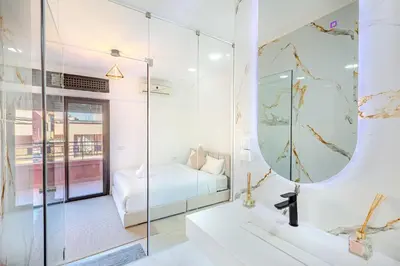 a bathroom with a glass shower and a bed at modern friendly appt in gueliz in Marrakech