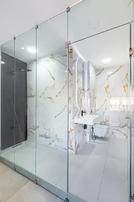 a glass shower in a bathroom with a sink at modern friendly appt in gueliz in Marrakech