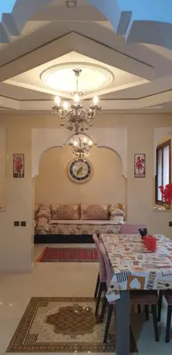 a dining room with a table and a chandelier at Mabrouka in Marrakech