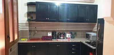 a kitchen with black cabinets and a counter top at Mabrouka in Marrakech
