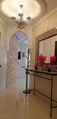 a room with a mirror and a table with flowers on it at Mabrouka in Marrakech