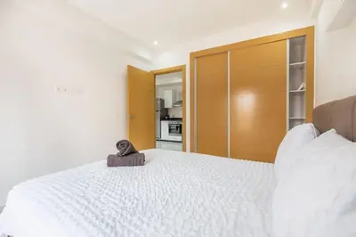 a bedroom with a large white bed with a wooden headboard at New! Guéliz , Modern , Terrasse in Marrakech