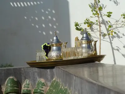 a tray of tea pots and glasses on a table at Riad Dar Alamane in Marrakech