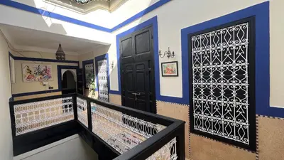 a hallway with blue and white walls and a black door at Riad Mamma MARRAKESH in Marrakech