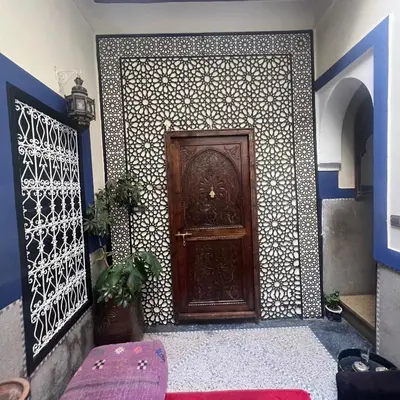 a wooden door in a room with a wall at Riad Mamma MARRAKESH in Marrakech
