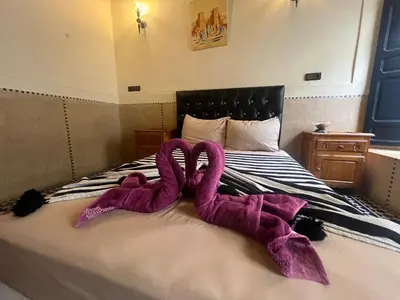 two purple towels sitting on top of a bed at Riad Mamma MARRAKESH in Marrakech