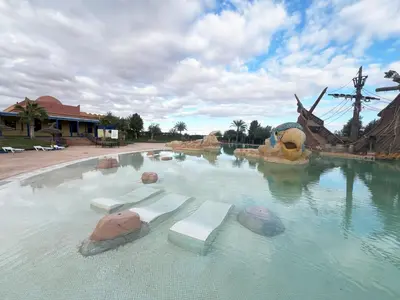 a water slide in a theme park with a windmill at Appartement avec Solarium Privé au Vizir Résidence Prestigieuse avec Accès au Parc in Marrakech