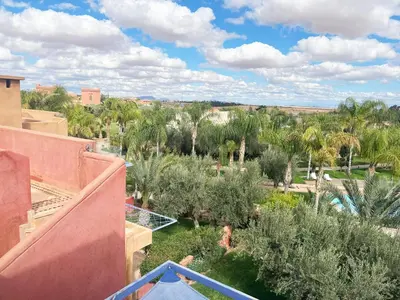 a view from the balcony of a resort with palm trees at Appartement avec Solarium Privé au Vizir Résidence Prestigieuse avec Accès au Parc in Marrakech