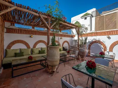 a patio with a couch and tables and chairs at Riad Kilimini & SPA in Marrakech