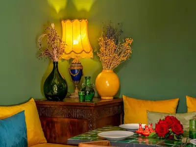 a living room with a table with vases and a lamp at Riad Kilimini & SPA in Marrakech