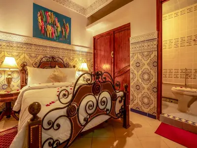 a bedroom with a bed and a bathroom with a sink at Pretty Apartment in the Medina in Marrakech