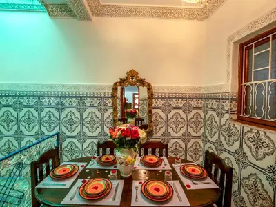 a dining room with a table and a mirror at Pretty Apartment in the Medina in Marrakech