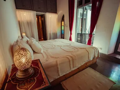 a bedroom with a bed and a lamp on a table at Riad La Smala in Marrakech