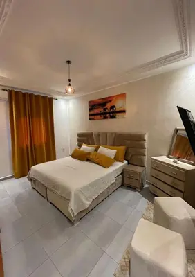 a bedroom with a bed and a television in it at Appartements Guéliz Zerktouni in Marrakech