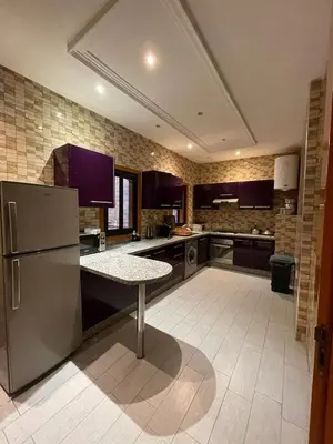 a kitchen with a refrigerator and a table in it at Appartements Guéliz Zerktouni in Marrakech