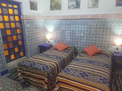 two beds sitting next to each other in a room at Riad dar kader C in Marrakech