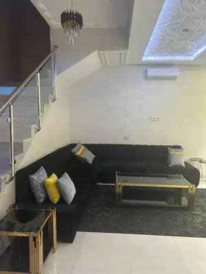 a black couch in a living room with a staircase at Villa djelloul s in Marrakech