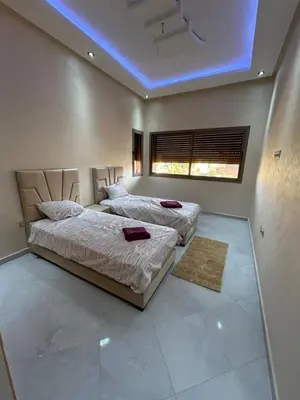 two beds in a bedroom with a blue ceiling at Villa djelloul s in Marrakech