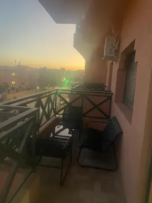 a balcony with a table and chairs on a building at Appartement Moderne Premium in Marrakech