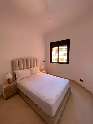 a bedroom with a large white bed with a window at Appartement Moderne Premium in Marrakech