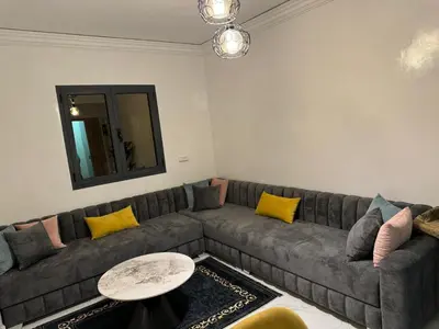 a living room with a gray couch with yellow pillows at Marrakech apartement in Marrakech