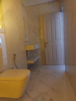 a bathroom with a yellow toilet and a white door at Marrakech apartement in Marrakech