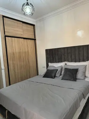 a bedroom with a large bed with a wooden door at Marrakech apartement in Marrakech
