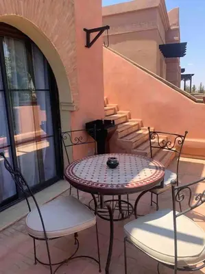 a patio with a table and chairs on a building at Havre de paix bohème avec rooftop privée in Marrakech