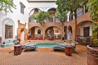 a courtyard with a swimming pool in a building at Riad Fleur d'Orient in Marrakech