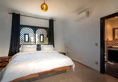 a bedroom with a bed and a window at Riad Tamazgha in Marrakech