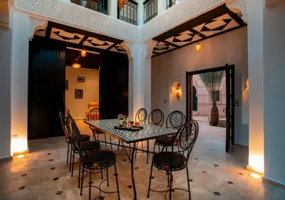 a dining room with a table and chairs at Riad Tamazgha in Marrakech