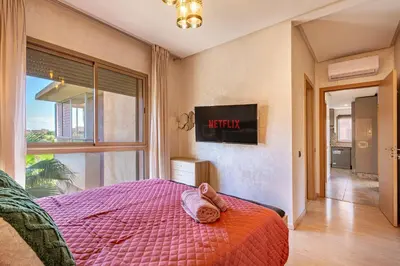 a bedroom with a bed with a cat laying on it at Luxury Living Flat in Prestigia Marrakech in Marrakech