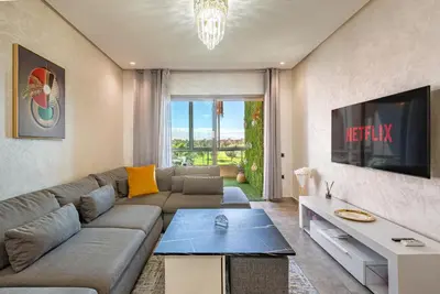 a living room with a couch and a tv at Luxury Living Flat in Prestigia Marrakech in Marrakech