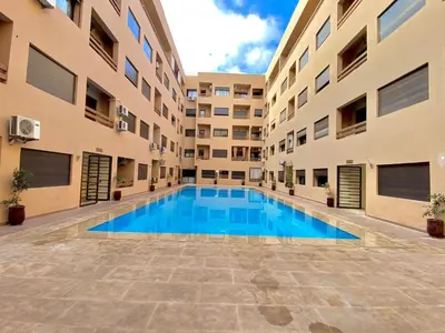 a swimming pool in the middle of a building at Studio au centre ville de marrakech avec piscine in Marrakech