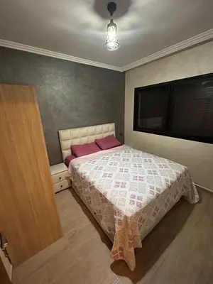 a bedroom with a bed and a large television at Studio au centre ville de marrakech avec piscine in Marrakech